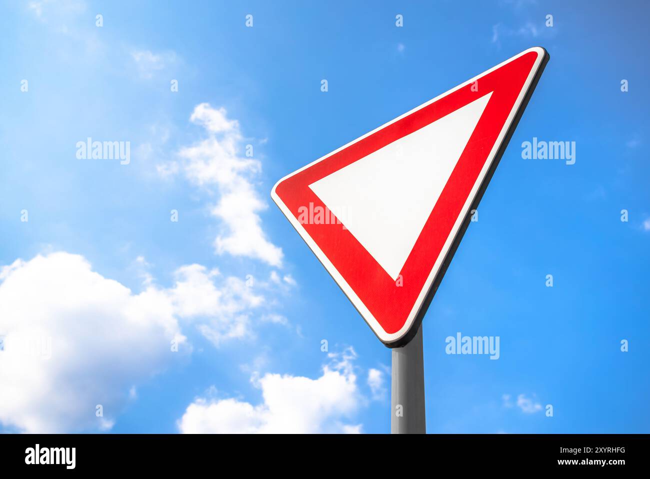 Yield Right-of-Way. This sign indicates driver must yield to traffic on the upcoming priority road. If necessary, come to a complete stop to allow tra Stock Photo