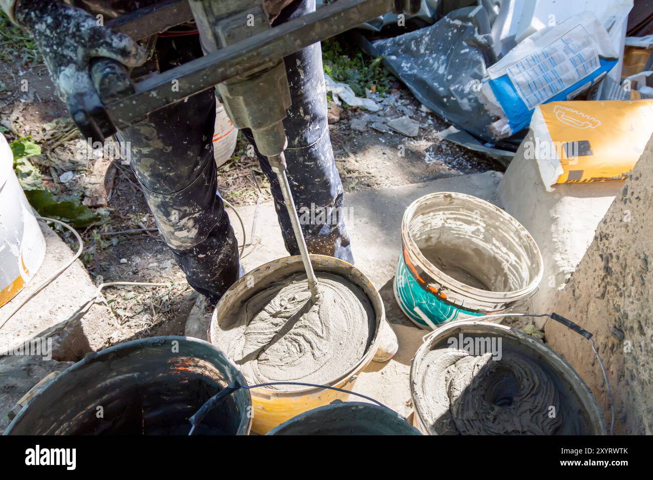 The Master At The Construction Site Mixes Glue With Water Preparing