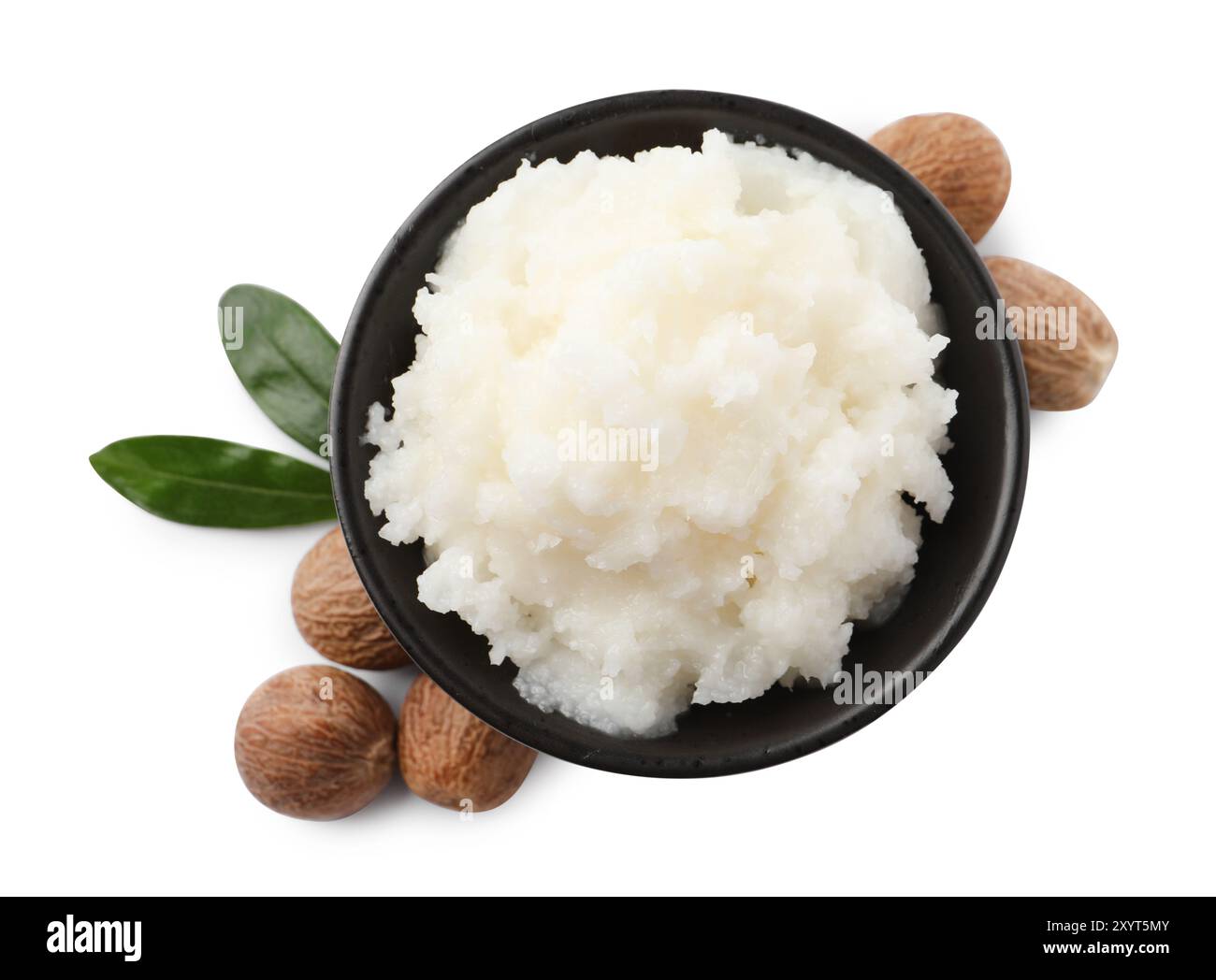 Natural shea butter in bowl, nuts and green leaves isolated on white ...