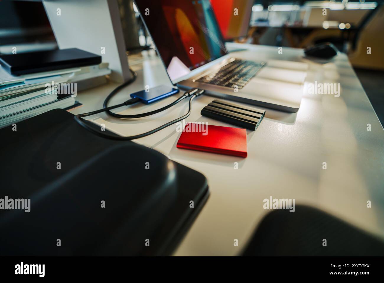 External ssd drive. Data storage backup mobile synchronisation. Encrypted files laptop office interior. Stock Photo