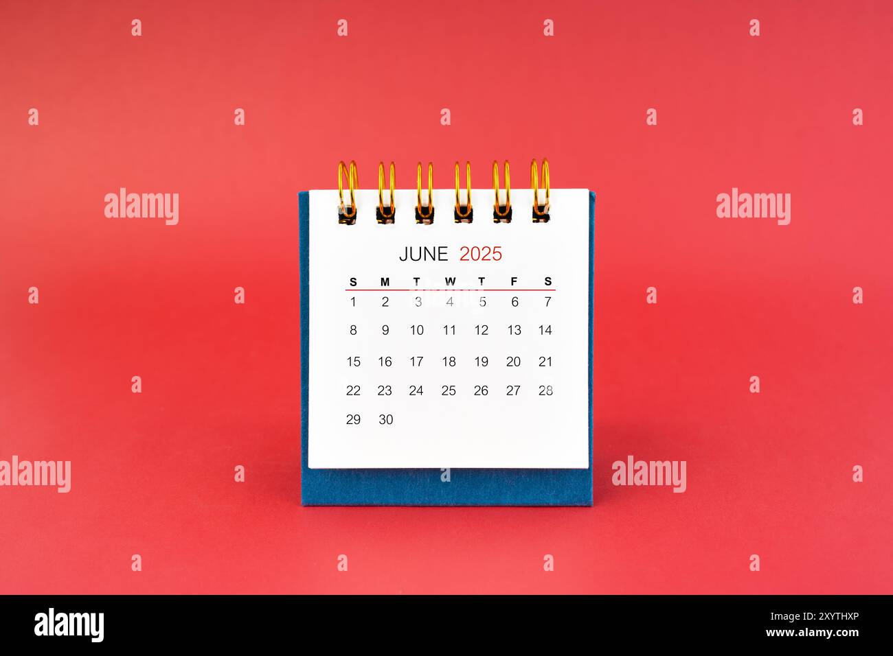 June 2025 white desk calendar on red color background Stock Photo - Alamy