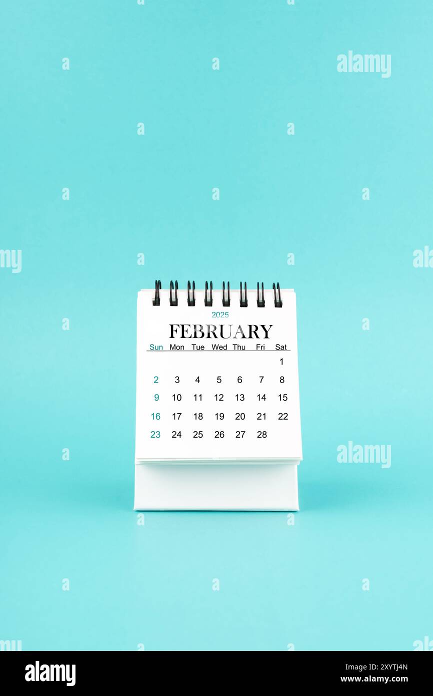 February 2025 white desk calendar on blue color background Stock Photo ...