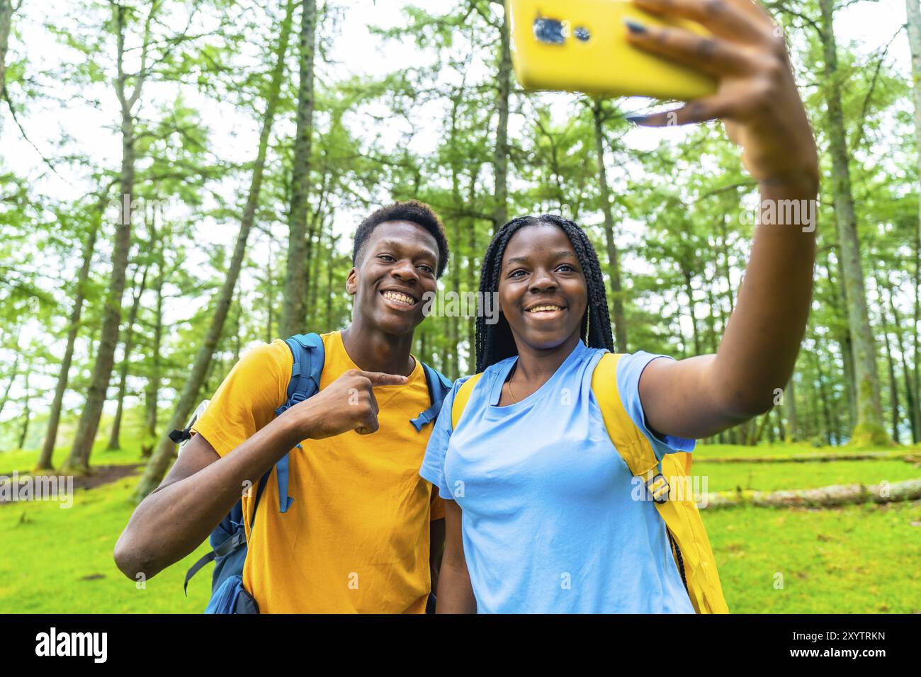 Two female and male young african hikers taking selfie in the forest ...