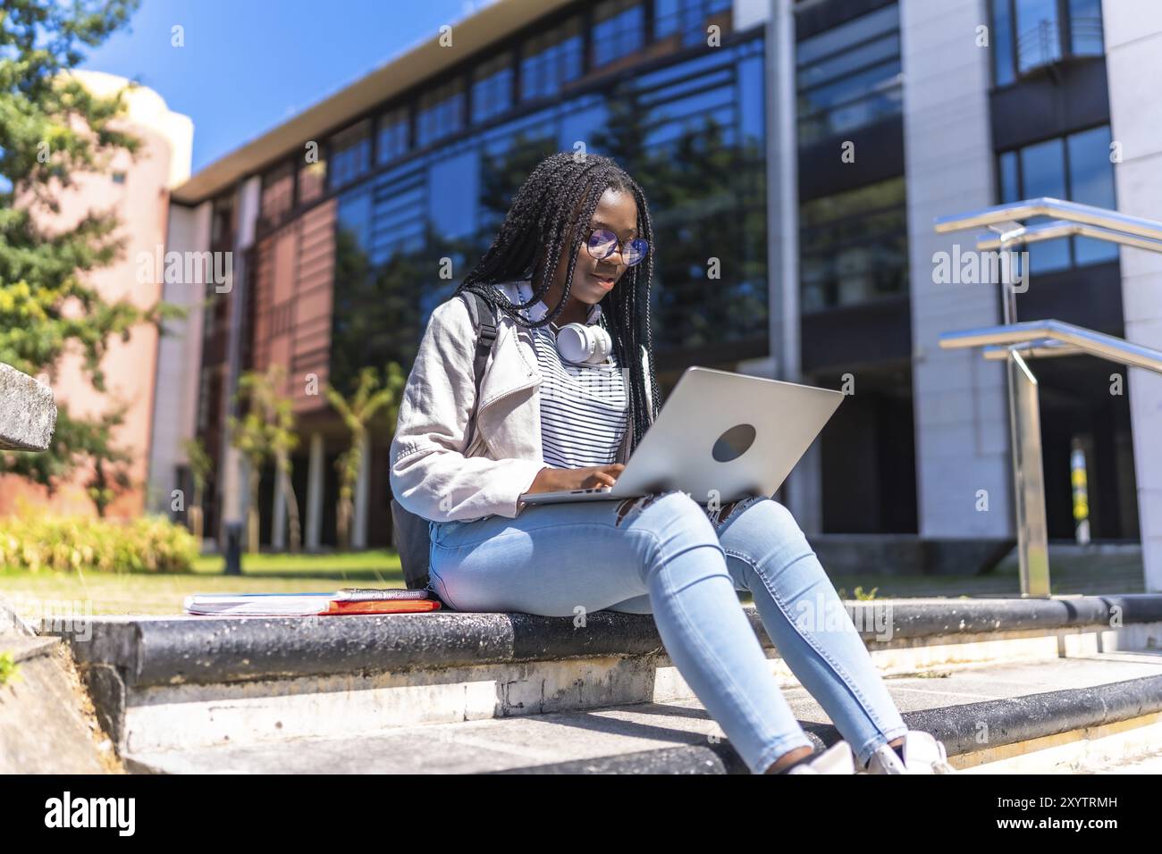 Focused female african university student using laptop sitting on ...