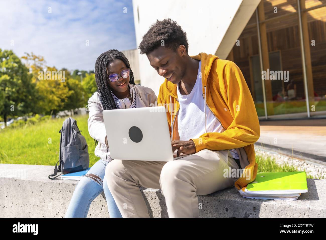 Cheerful african american students using laptop studying together ...