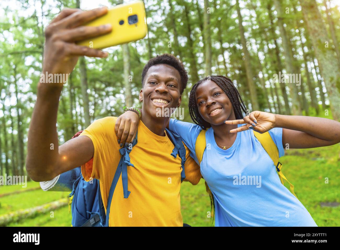 Cheerful african friends taking selfie gesturing victory with hand ...