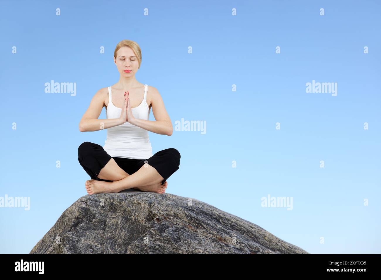 Yoga exercise in the lotus position on a rock Stock Photo - Alamy