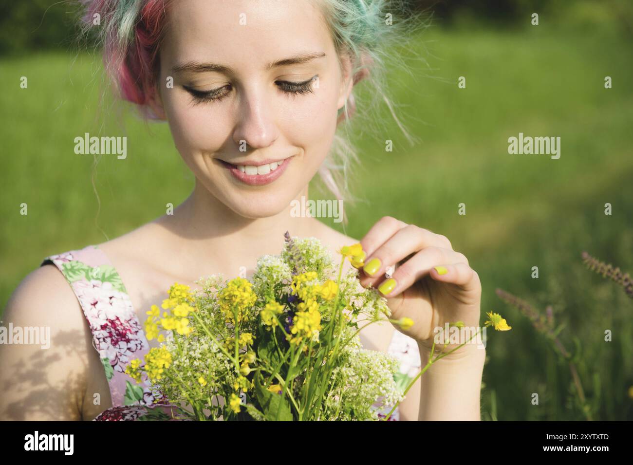 Portrait of a young happy smiling girl in a cotton dress with a bouquet ...