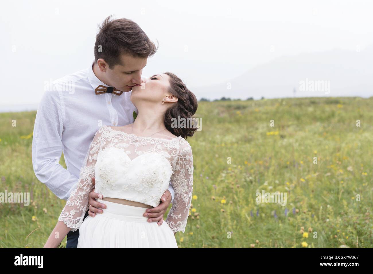 Young newlyweds are hugging and kissing being outdoors Stock Photo - Alamy