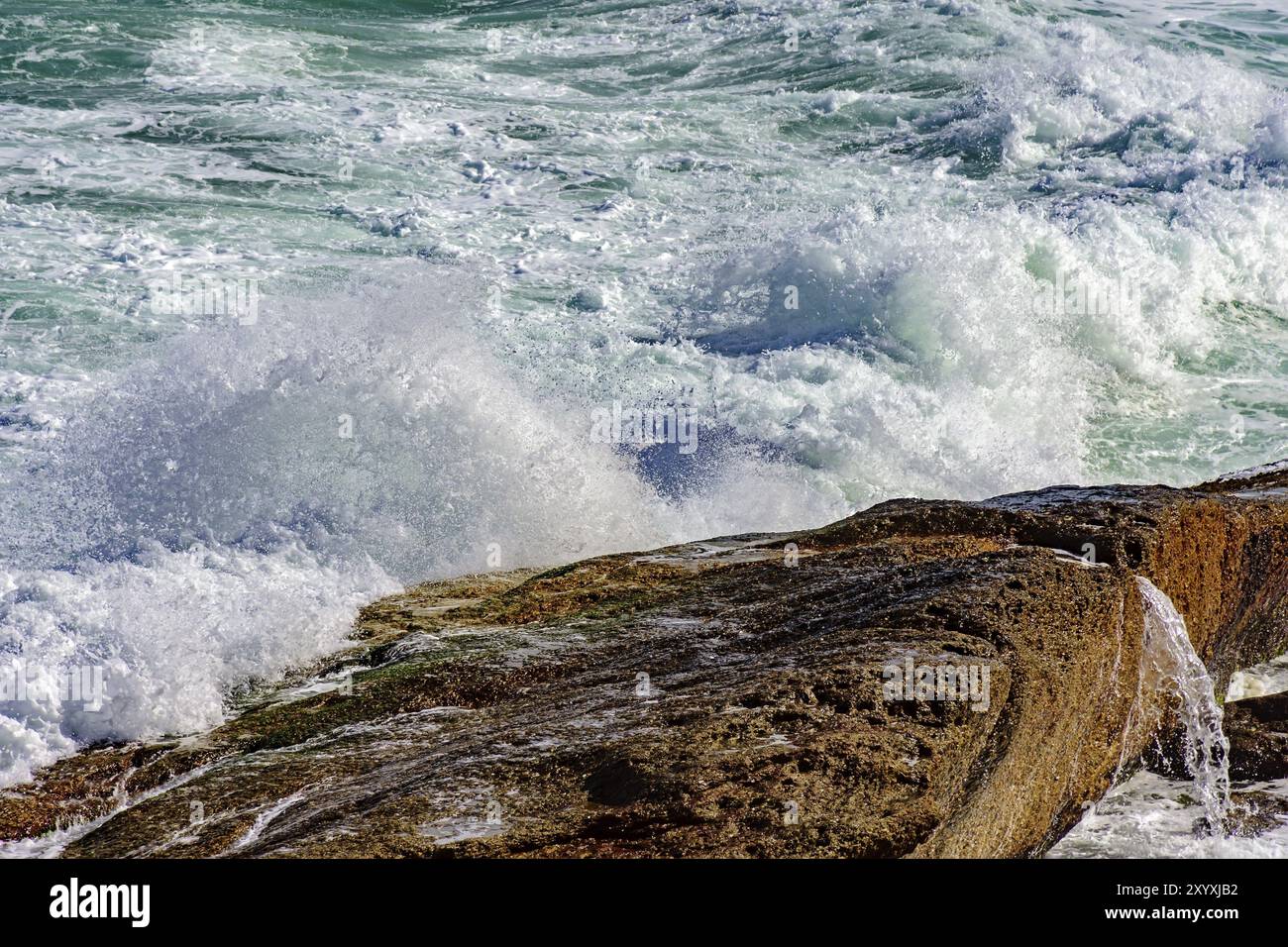 Storm Vs Rocks Wave crashing against rocks during storm Stock Photo - Alamy