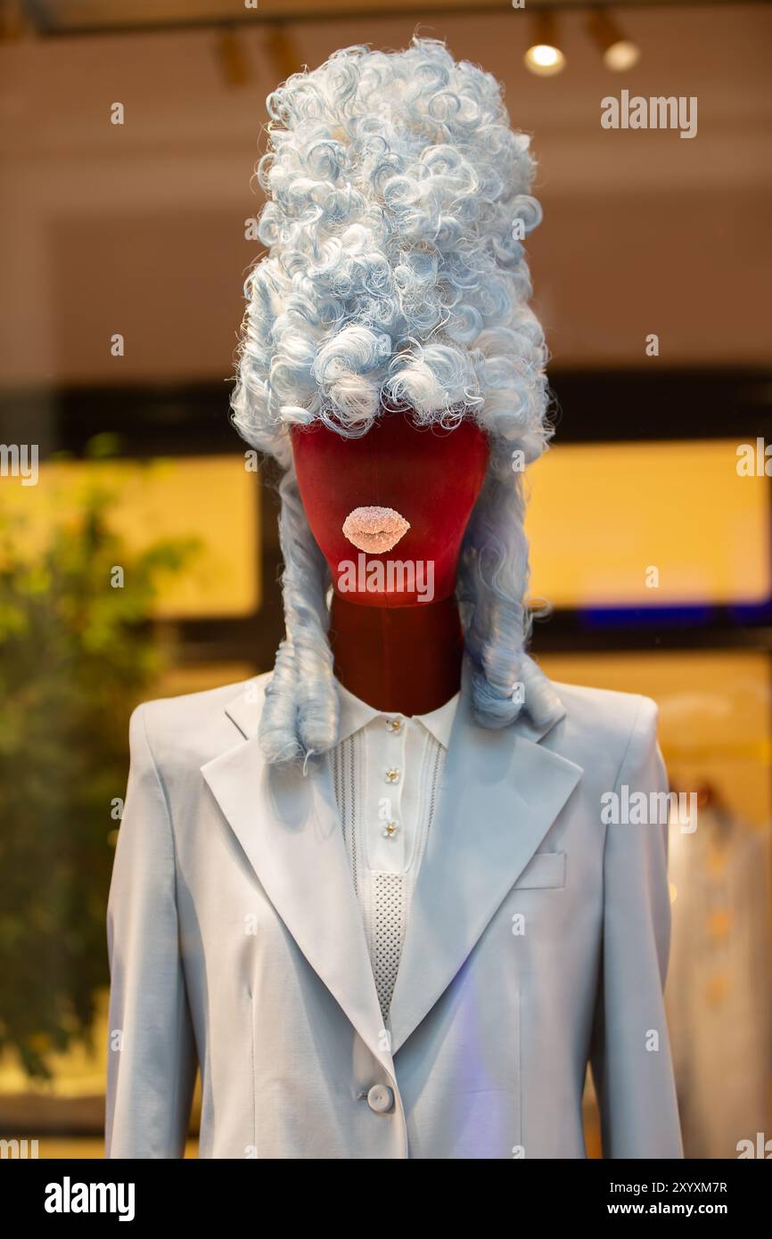 Creative female mannequin in a high retro wig and protruding rag lips. A mixture of centuries and styles. Stock Photo