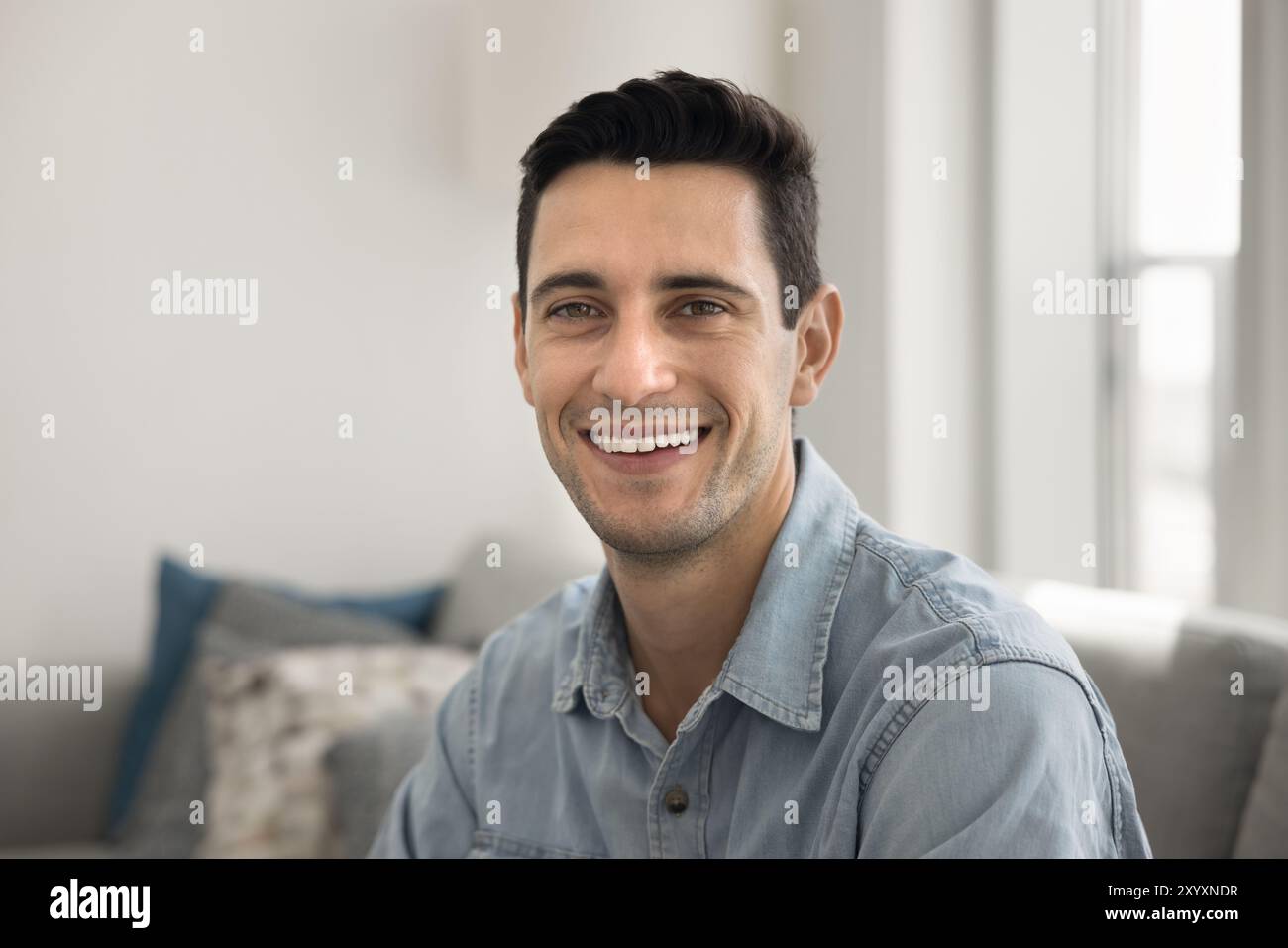 Happy handsome young Hispanic man looking at camera Stock Photo