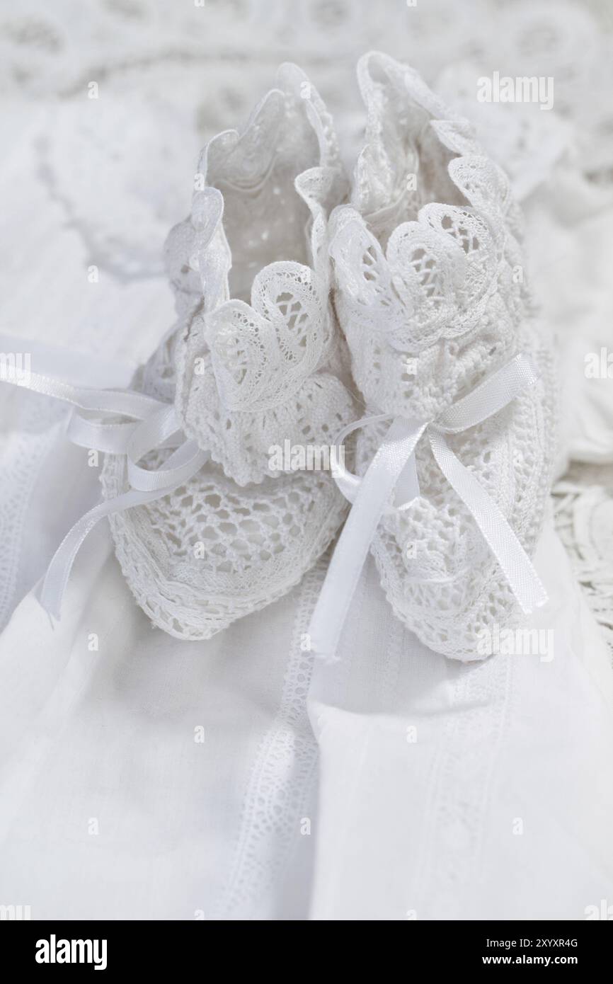 Baby girl shoes on white dress background. Christening Stock Photo - Alamy