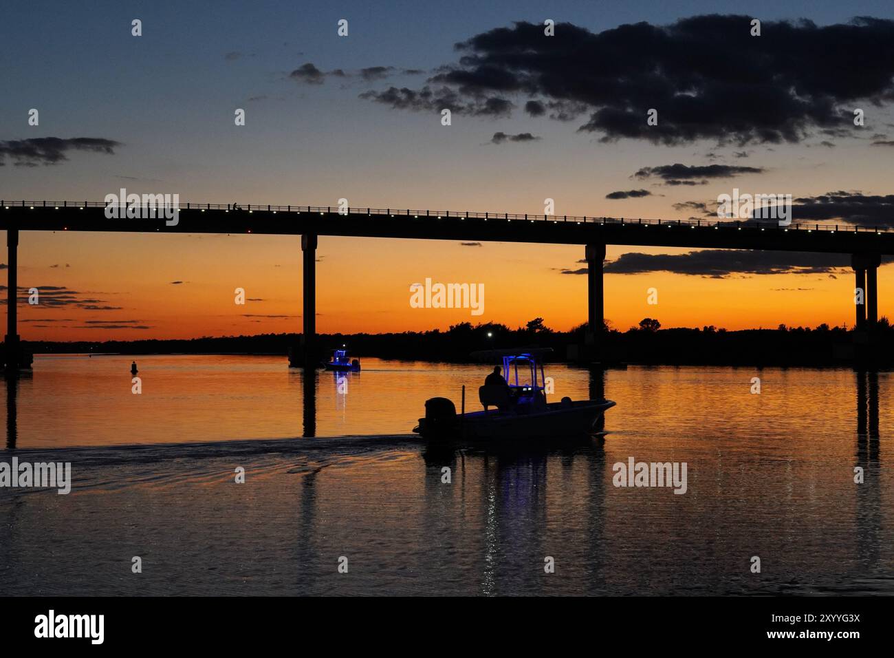 Boats in Silhouette under the Bridge at Sunset Stock Photo - Alamy
