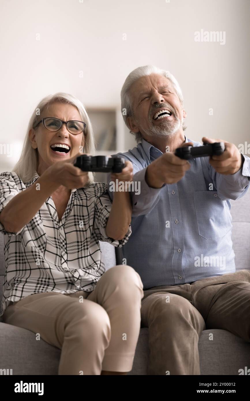 Cheerful excited senior 60s couple playing videogames Stock Photo
