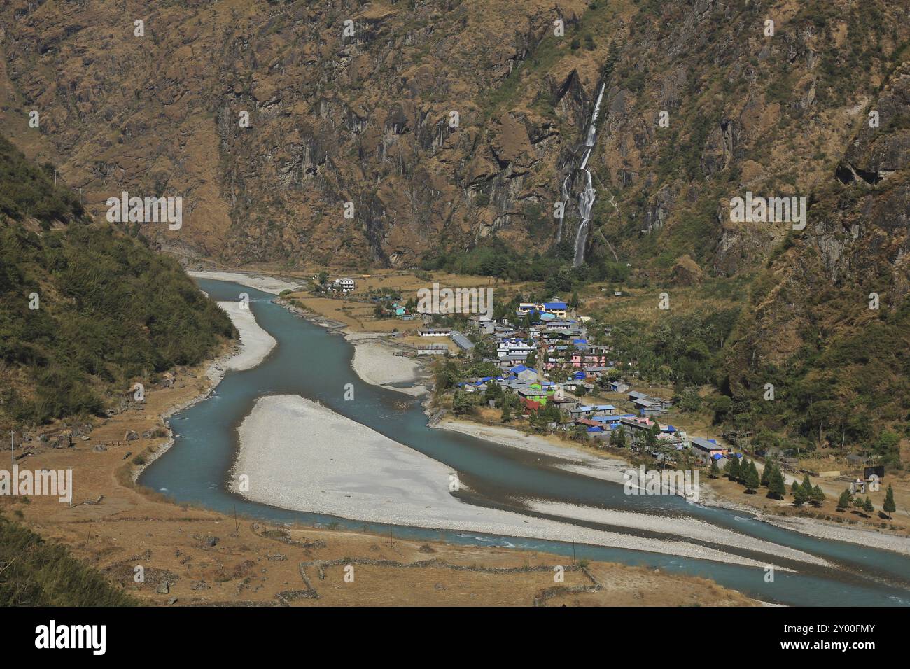 Scene in the Annapurna Conservation Area, Nepal. Turquoise Marsyangdi river. Colorful houses of Tal. Waterfall Stock Photo