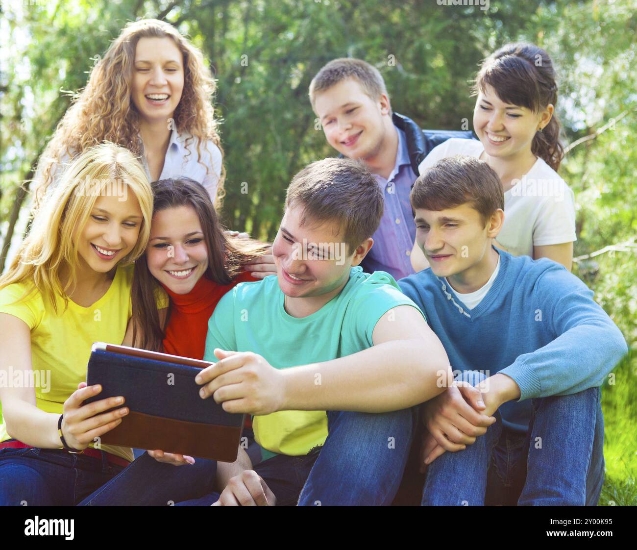 Young college students using tablet computer while doing homework in the park Stock Photo