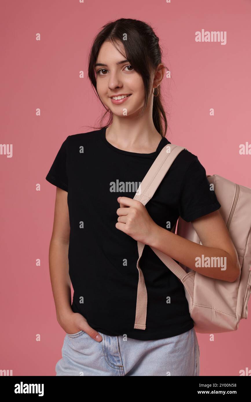 Portrait of cute teenage girl with backpack on pink background Stock ...