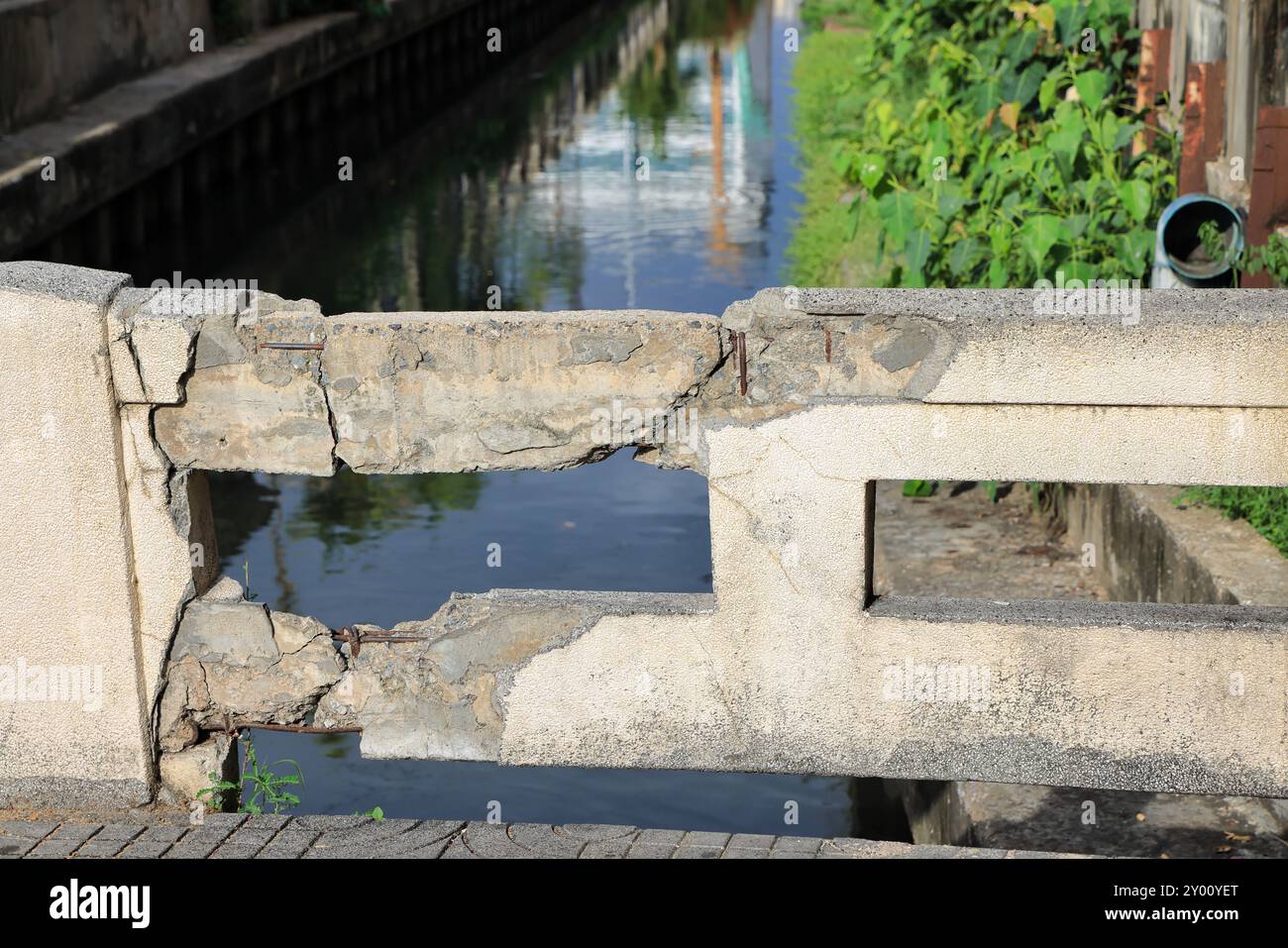 Cracked grey concrete surface with visible reinforcement, Rust in reinforcement of Concrete bridge, Broken or weak concrete. Stock Photo