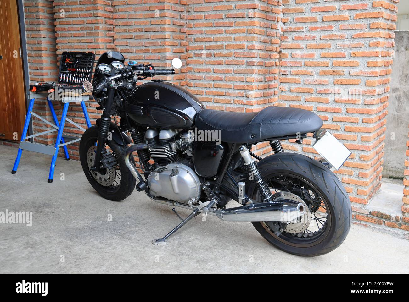 A classic Motorbike Standing in a Creative Workshop. Vintage Style Motorcycle in a Garage. Stock Photo