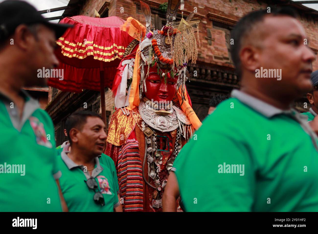 A person concealed inside the idol of Deity Dipankar Buddha dances while parading around the ancient city to receive prayers offered by devotees during the Pancha Dan festival in Bhaktapur Durbar Square. The festival's major highlights are giving away five elements, also known as five summer gifts including wheat grains, rice grains, salt, money, and fruit for prayers, wishing good health and prosperity. The Buddhists observe Pancha Dan by displaying gigantic antique statues of Deity Dipankar Buddha and devotees worshipping them across the historic city. Stock Photo