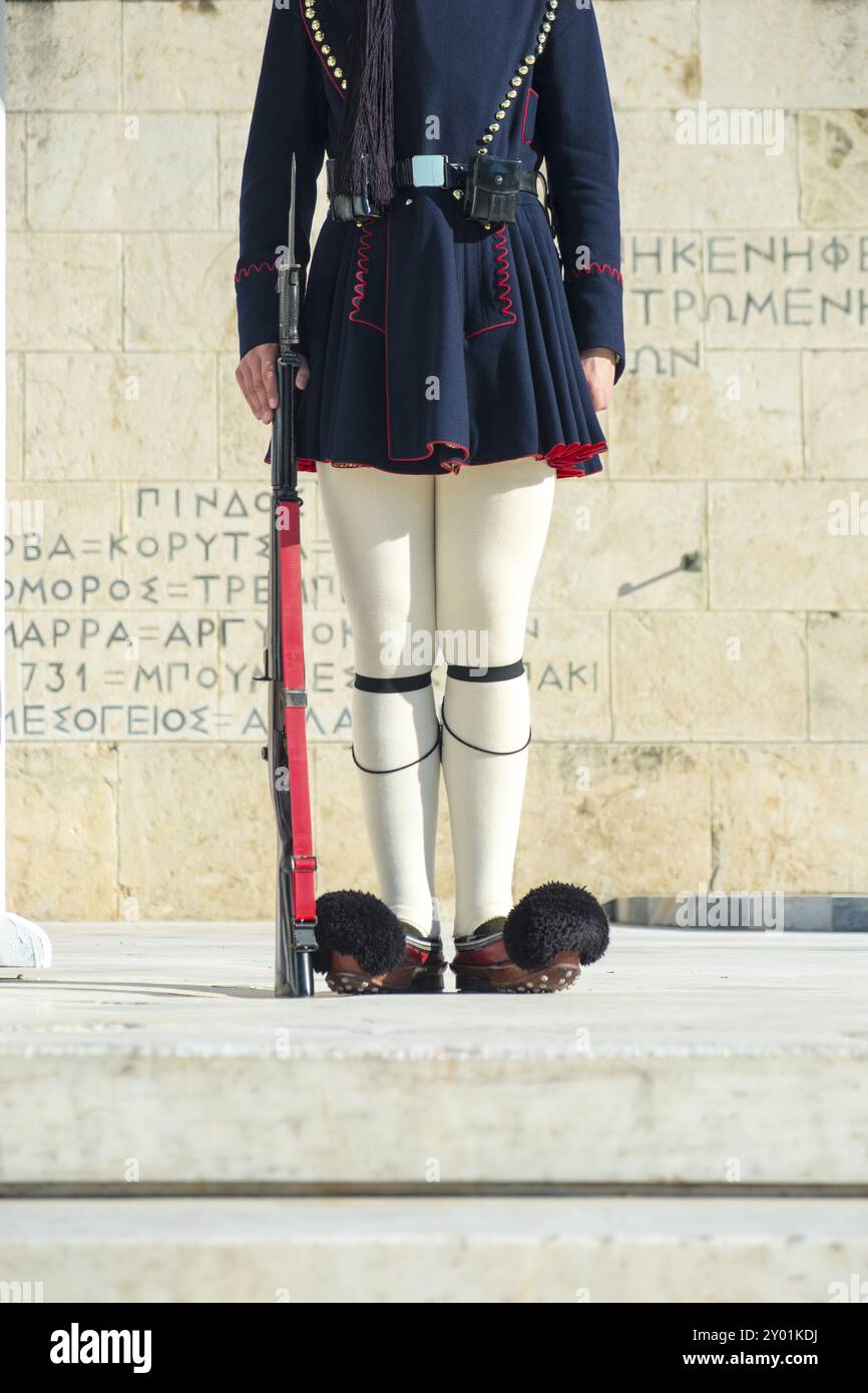 Traditional costume and rifle of legs of Evzone Presidential Guard in front of parliament building and tomb of unknown soldiers in Athens, Greece. Ver Stock Photo