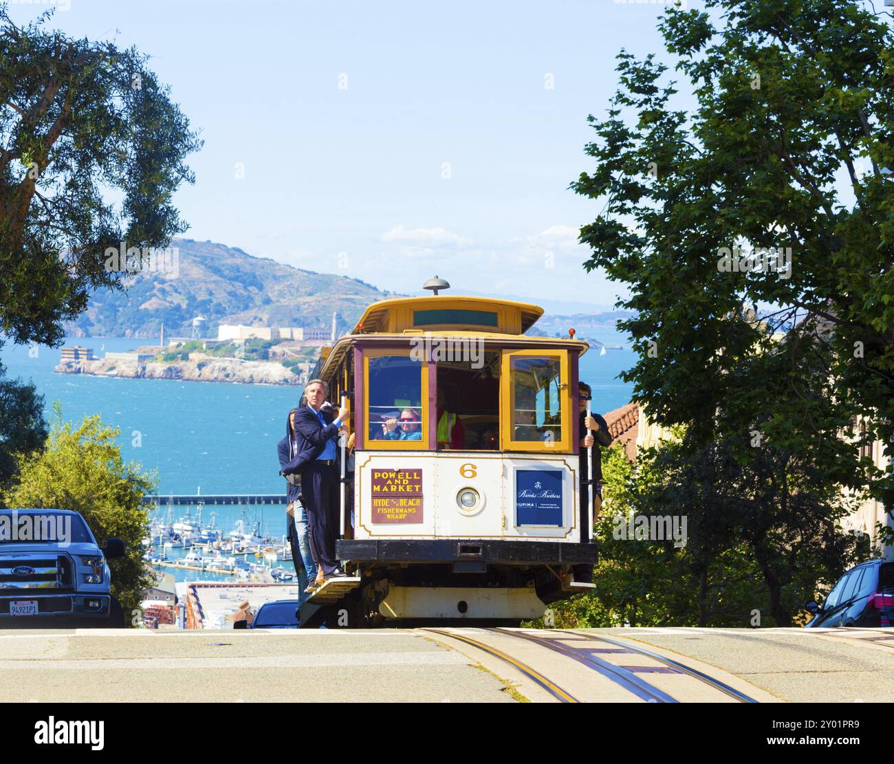 San Francisco, USA, May 15, 2016: Approaching cable car climbing over crest of hill with Alcatraz Island in background, North America Stock Photo