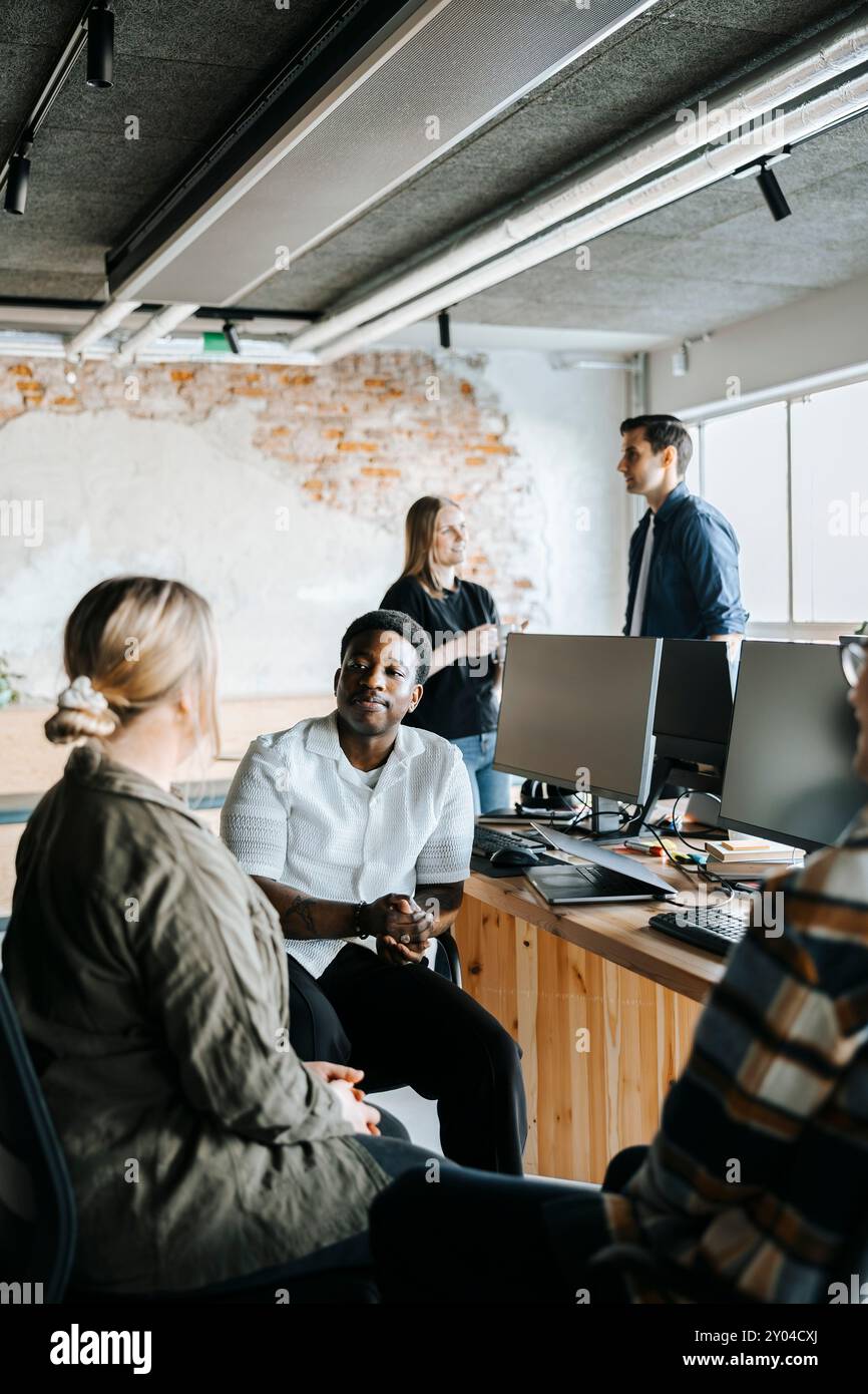 Male and female computer programmers discussing in office Stock Photo