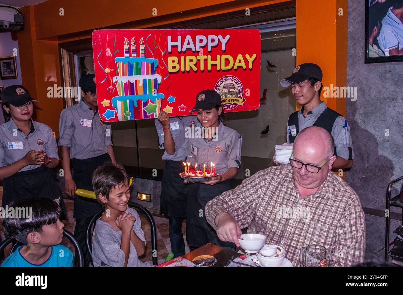 9 year old mixed race boy (Cambodian-American) celebrates his 9th birthday, Tawandang micro-brewery, Phnom Penh, Cambodia. © Kraig Lieb Stock Photo