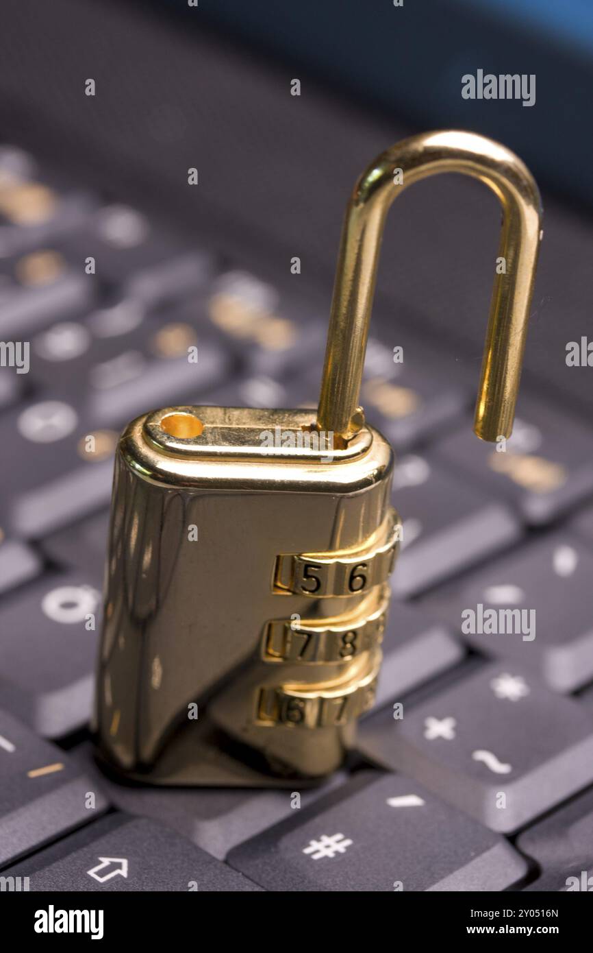 A golden padlock on a black notebook keyboard Stock Photo