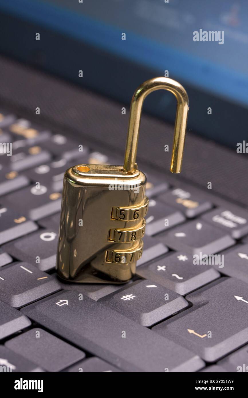 A golden padlock on a black notebook keyboard Stock Photo