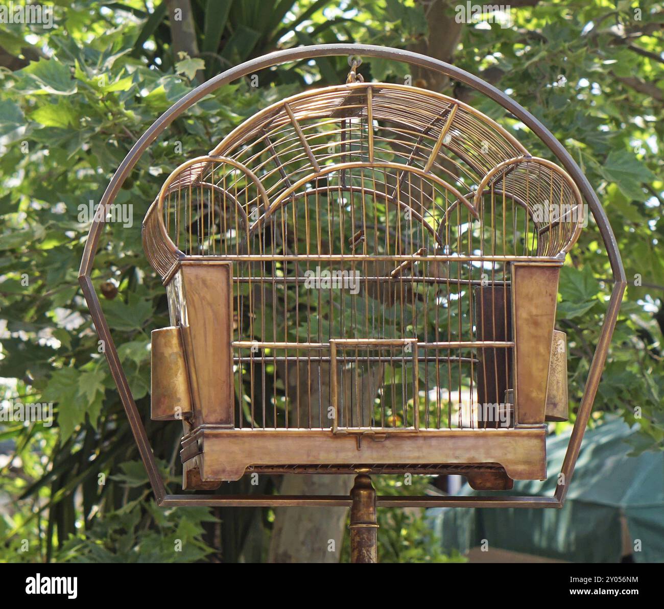 Empty vintage style metal birdcage at pole Stock Photo