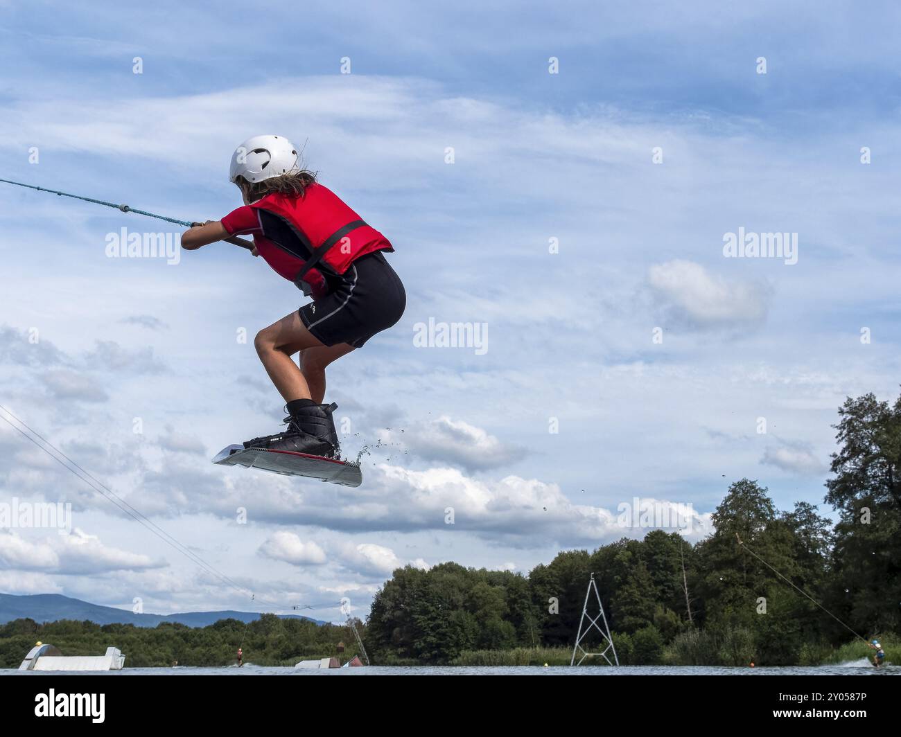 Boy or girl jumping and flying with wakeboard, water sports and water ...