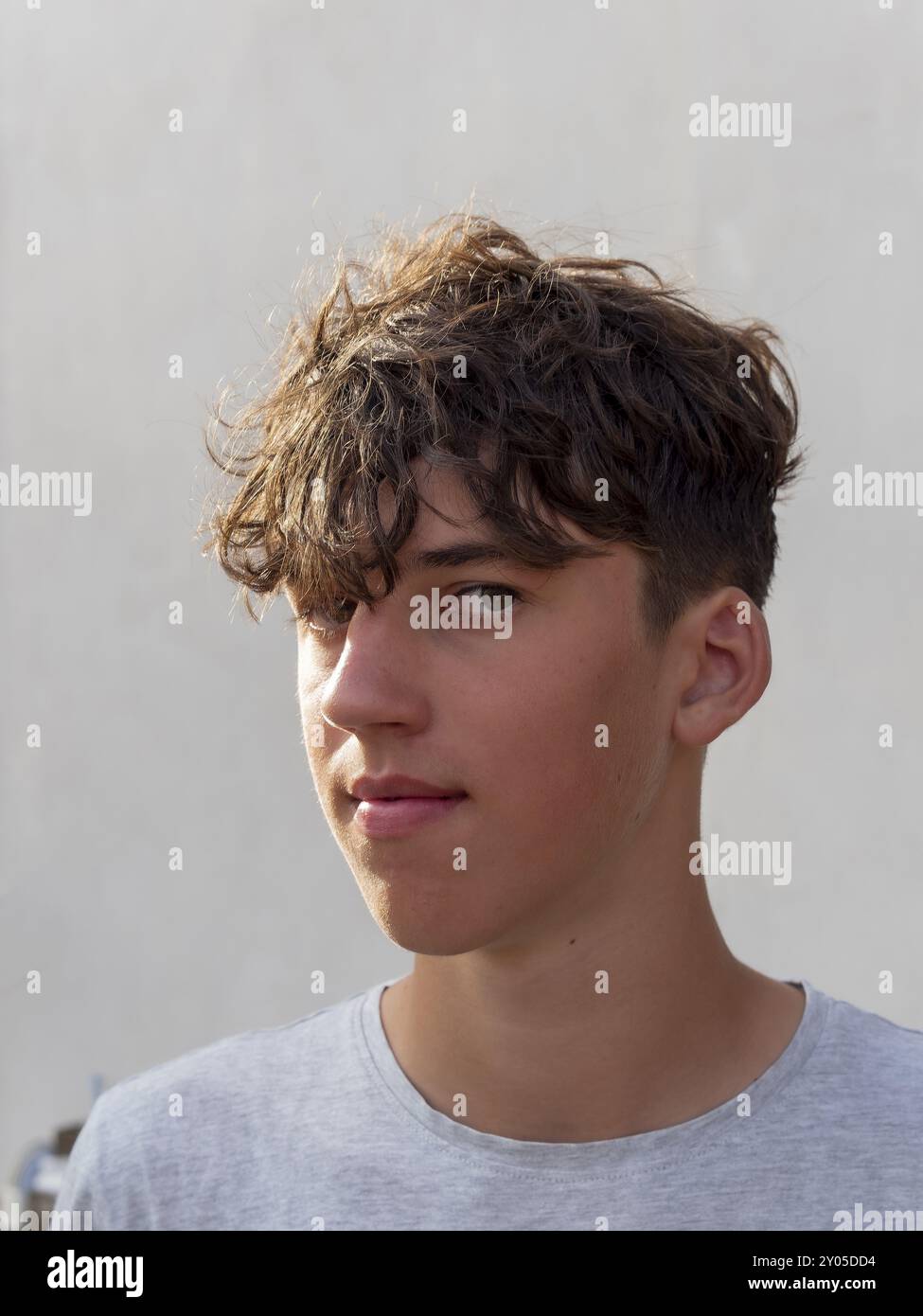 Portrait of a young athletic man with curly brown hair in front of a ...