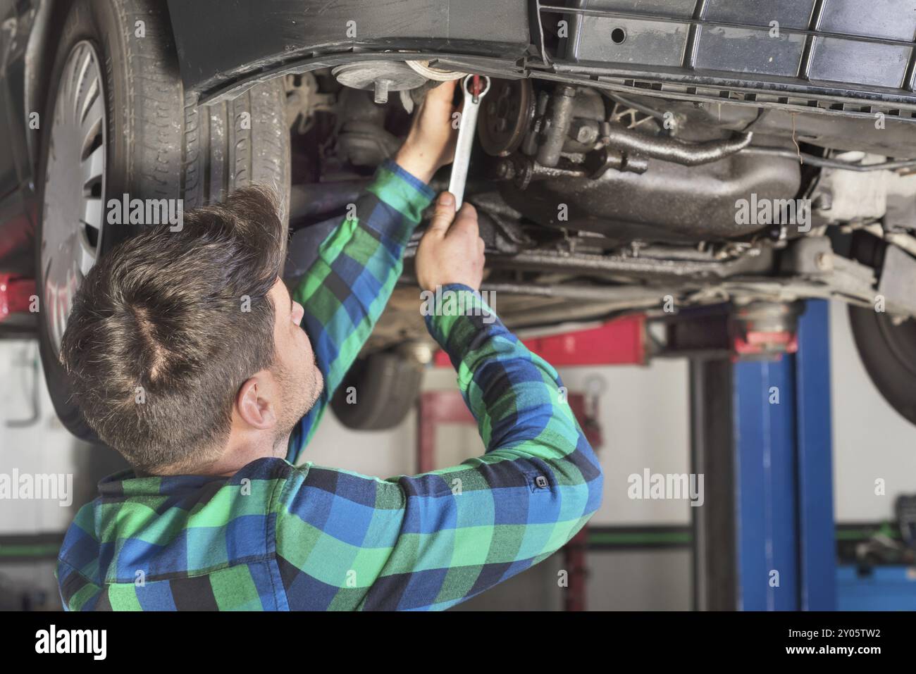 Portrait of mechanic repairing with a wrench a lifted car Stock Photo ...