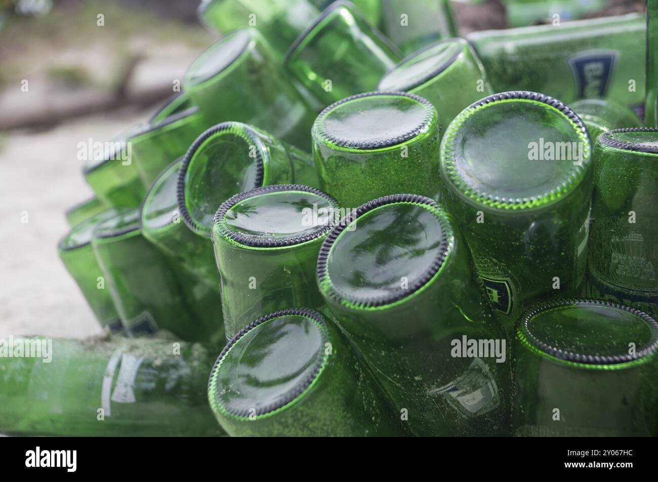 Beer Rings Polution Pile of empty green beer bottles thrown away on a beach illustrate ...