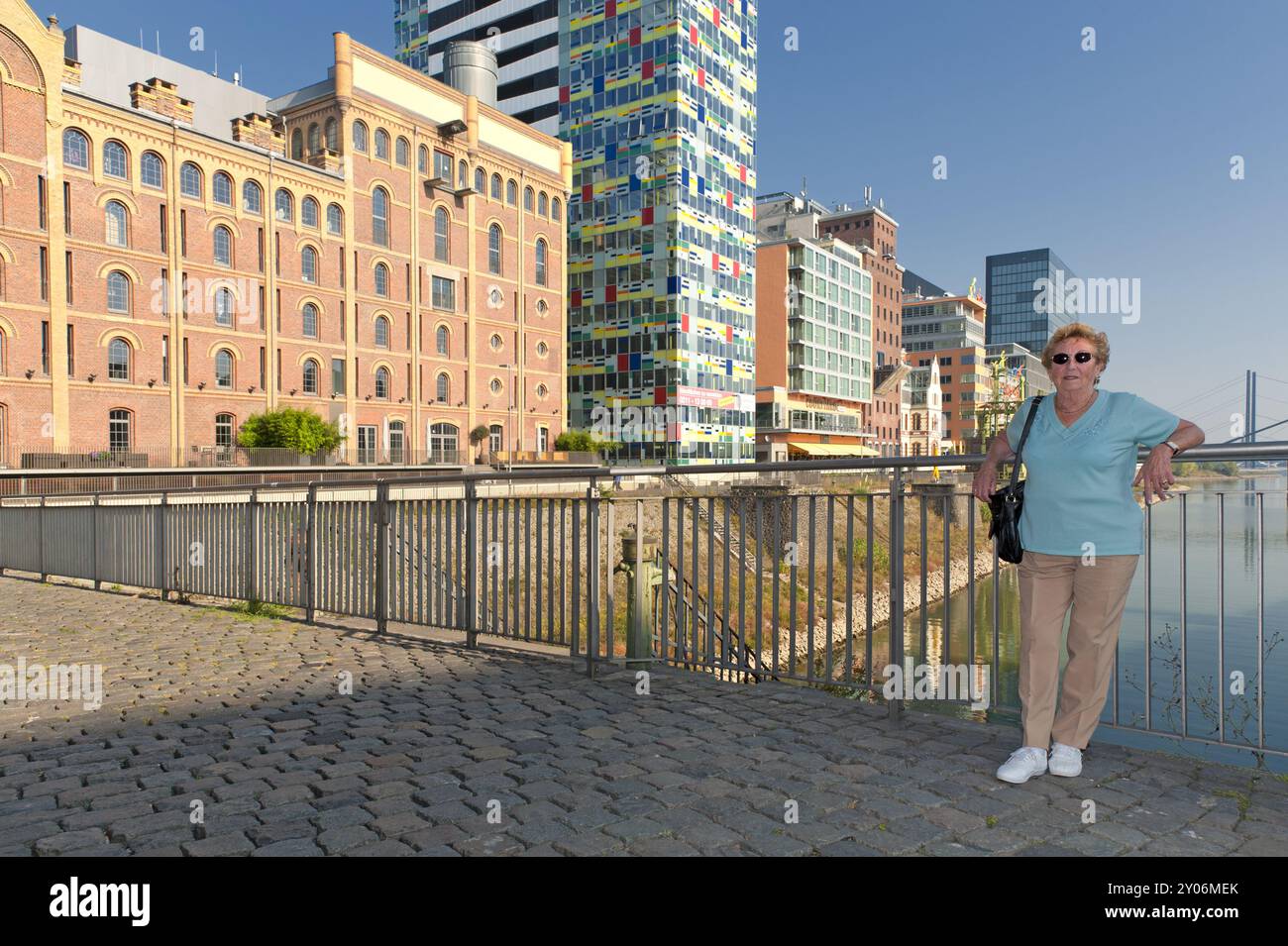 Seniorin steht im Duesseldorfer Medienhafen Stock Photo