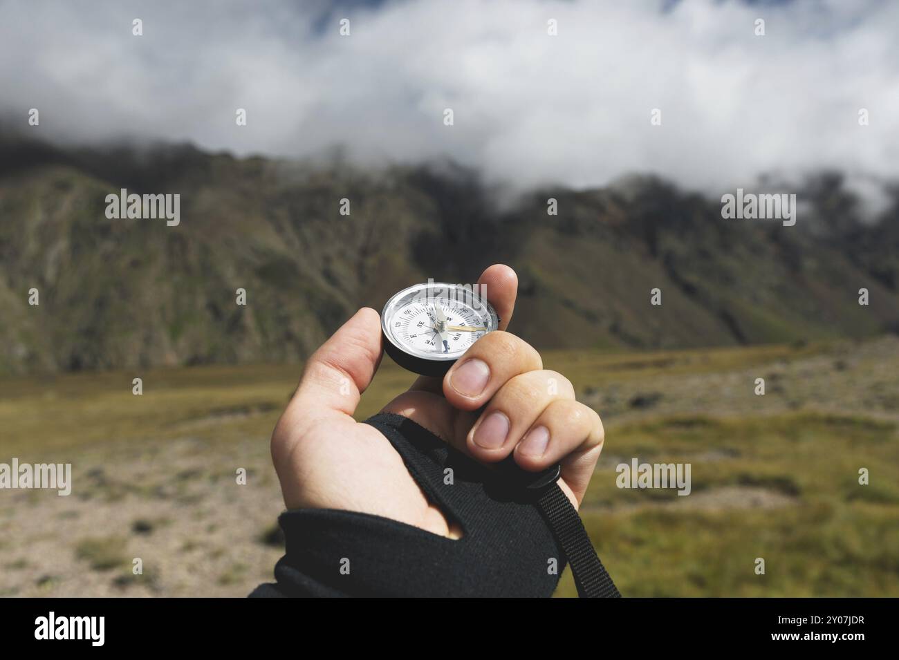 Viewpoint shot. A first-person view of a man's hand holds a compass ...