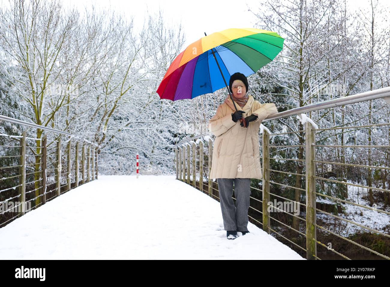 Woman standing with a colourful umbrella on a pedestrian bridge Stock ...