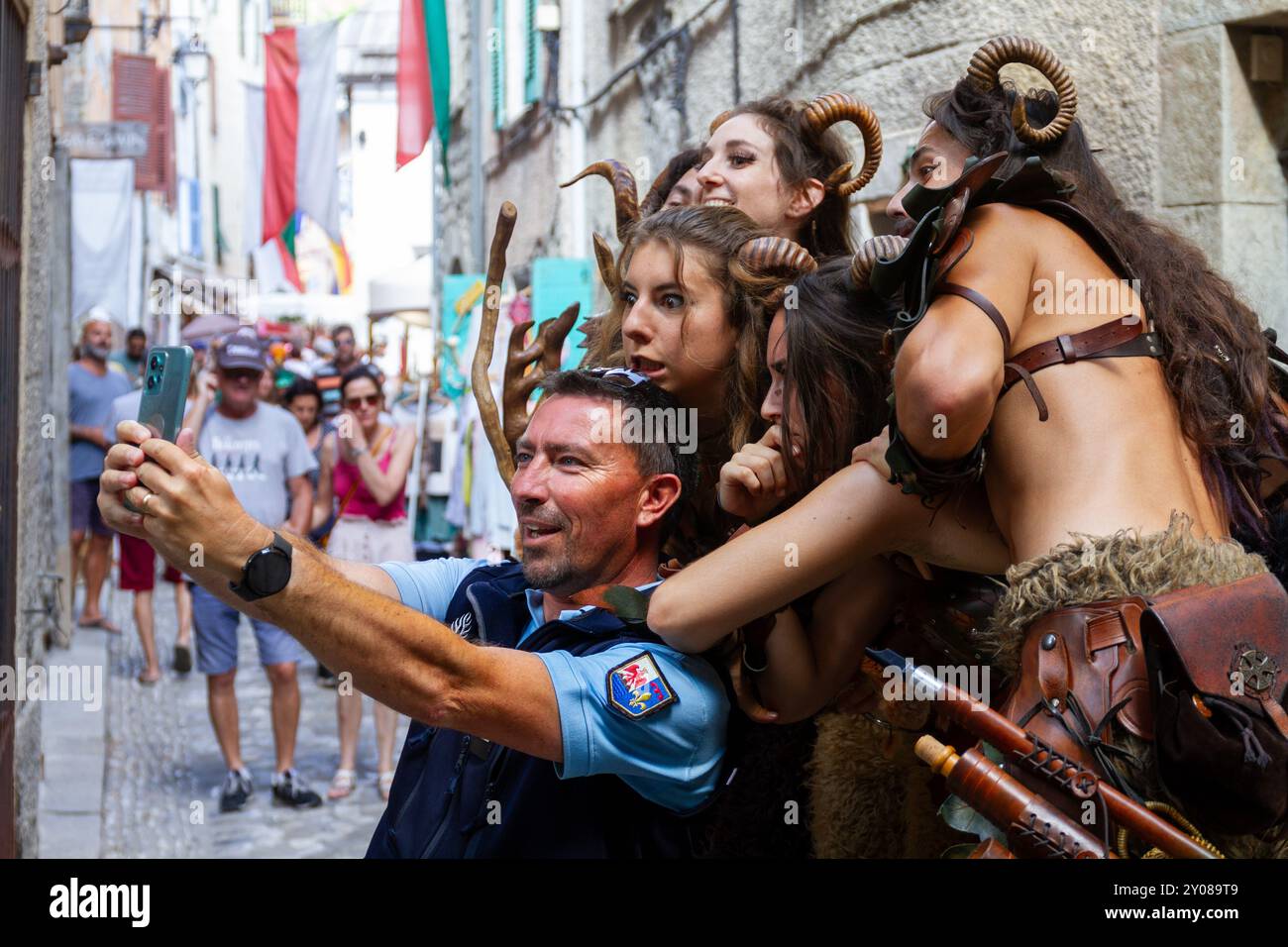 Medieval Fantasy Meets Modern Selfie: Street Performers and Policeman Interact at Urban Festival in France Stock Photo