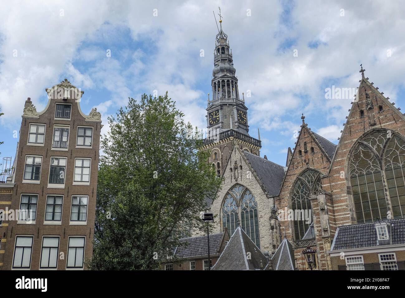 Gothic church with large windows and trees against a summer sky, Amsterdam, Netherlands Stock Photo