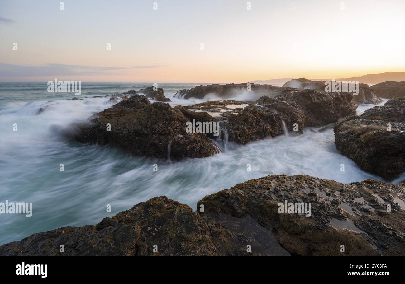 Waves washing over rocks by the sea, long exposure, coastal landscape ...