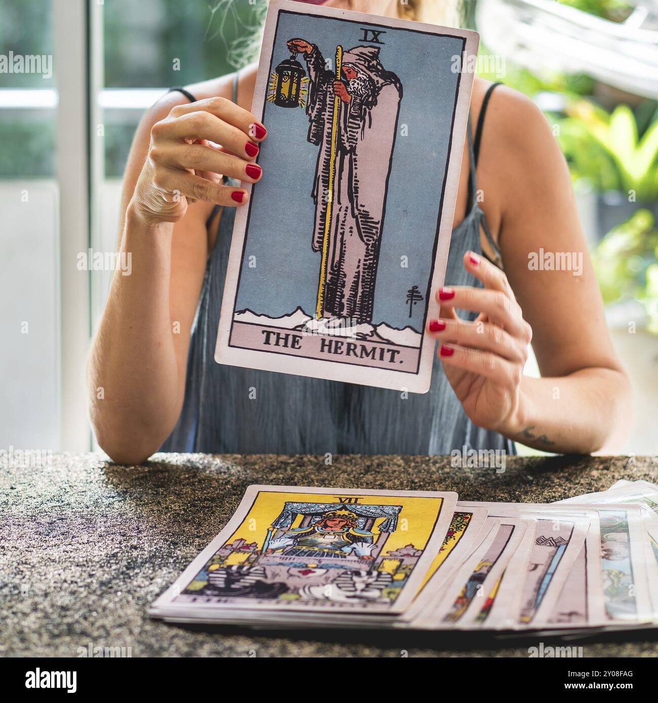 Close-up of the Tarot card The Hermit held by the tarot reader Stock Photo