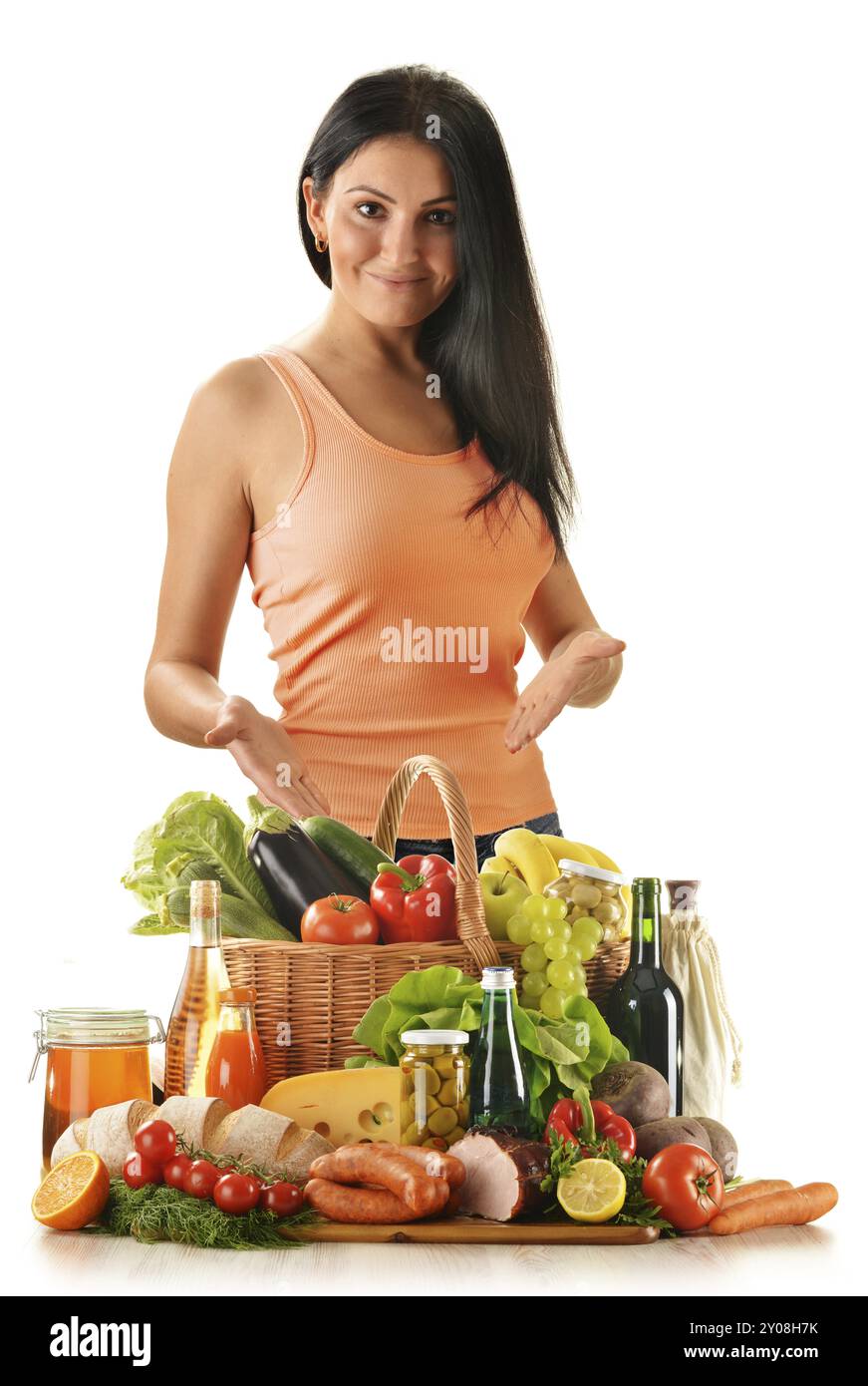 Young woman with variety of grocery products including vegetable, fruits, meat, dairy and wine Stock Photo