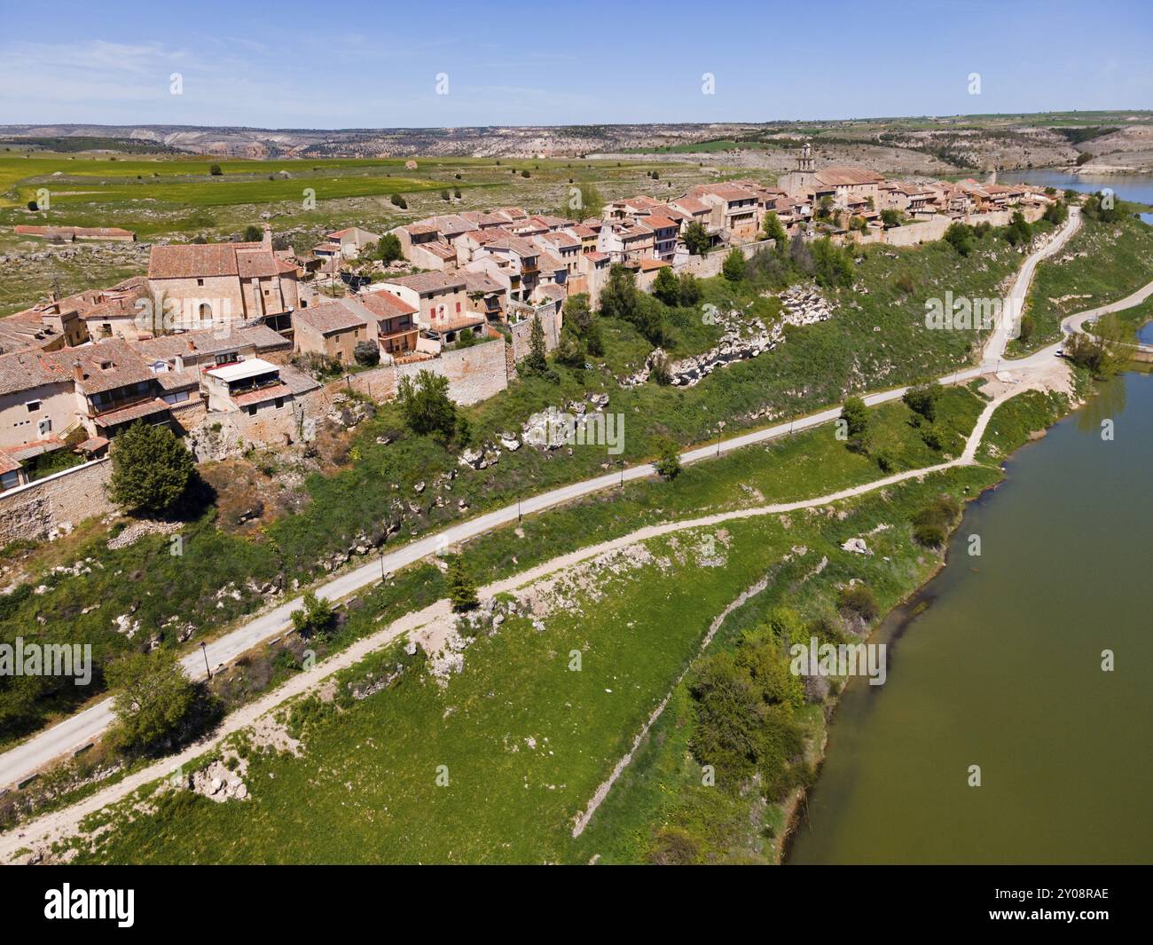 A riverside village with roads crossing the green surroundings and ...
