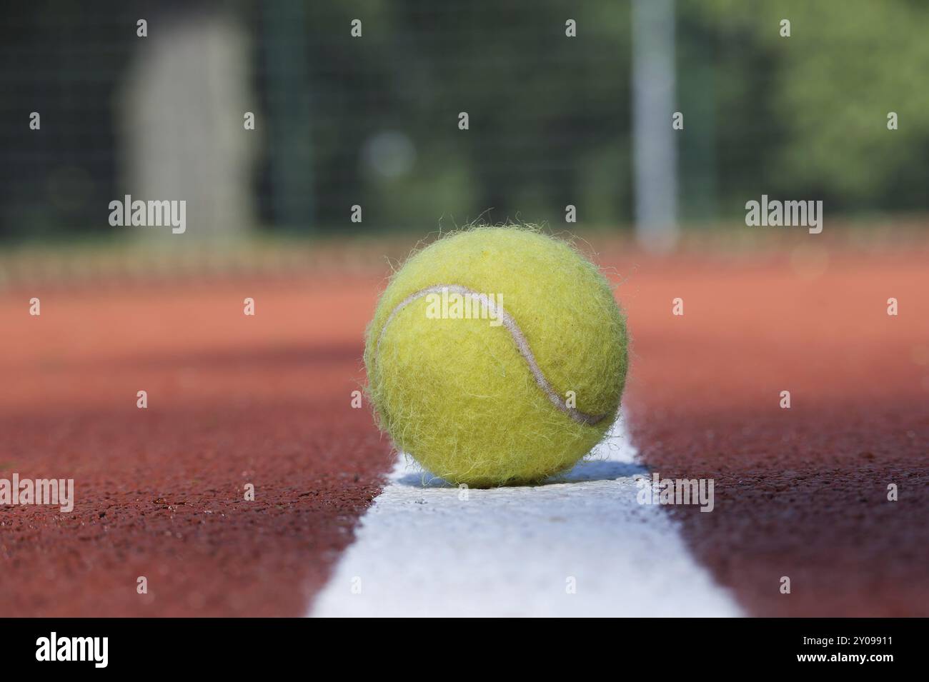 Tennis scene with white line and ball on hard court surface in low angle view Stock Photo