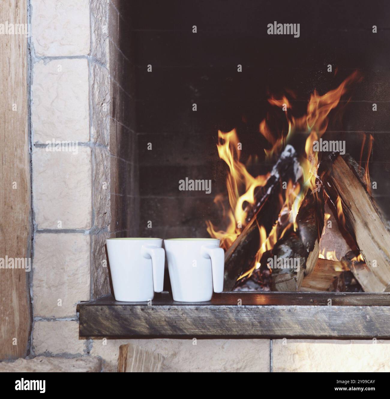 Two mugs near the fireplace with fire Stock Photo