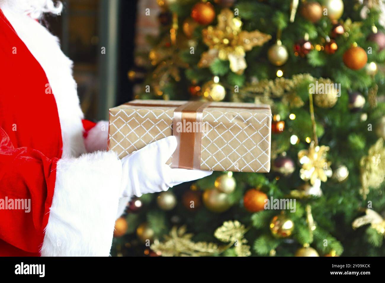 Santa Claus secretly putting gift box by the Christmas tree. Xmas Stock ...