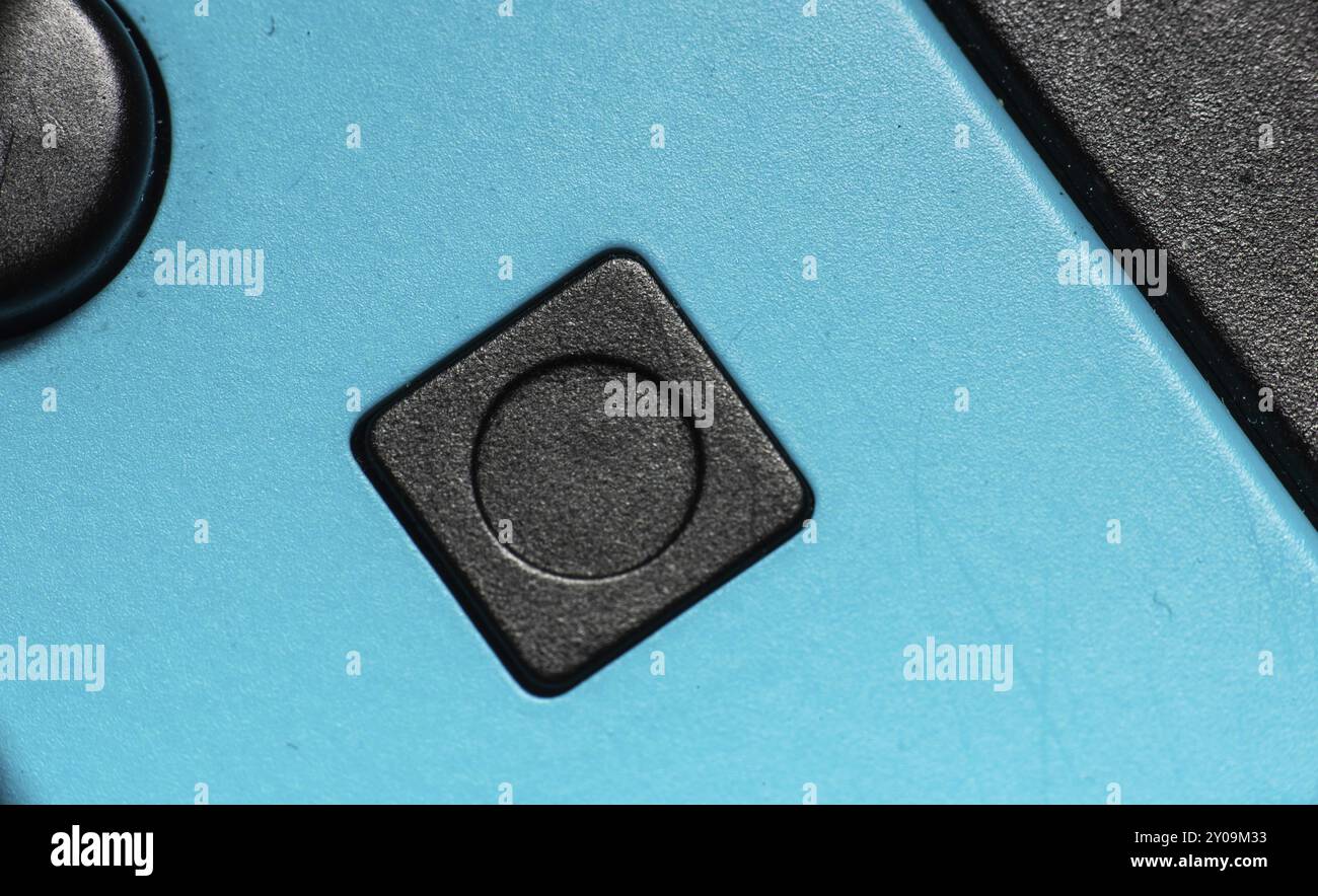 A black square button on a blue hand controller Stock Photo