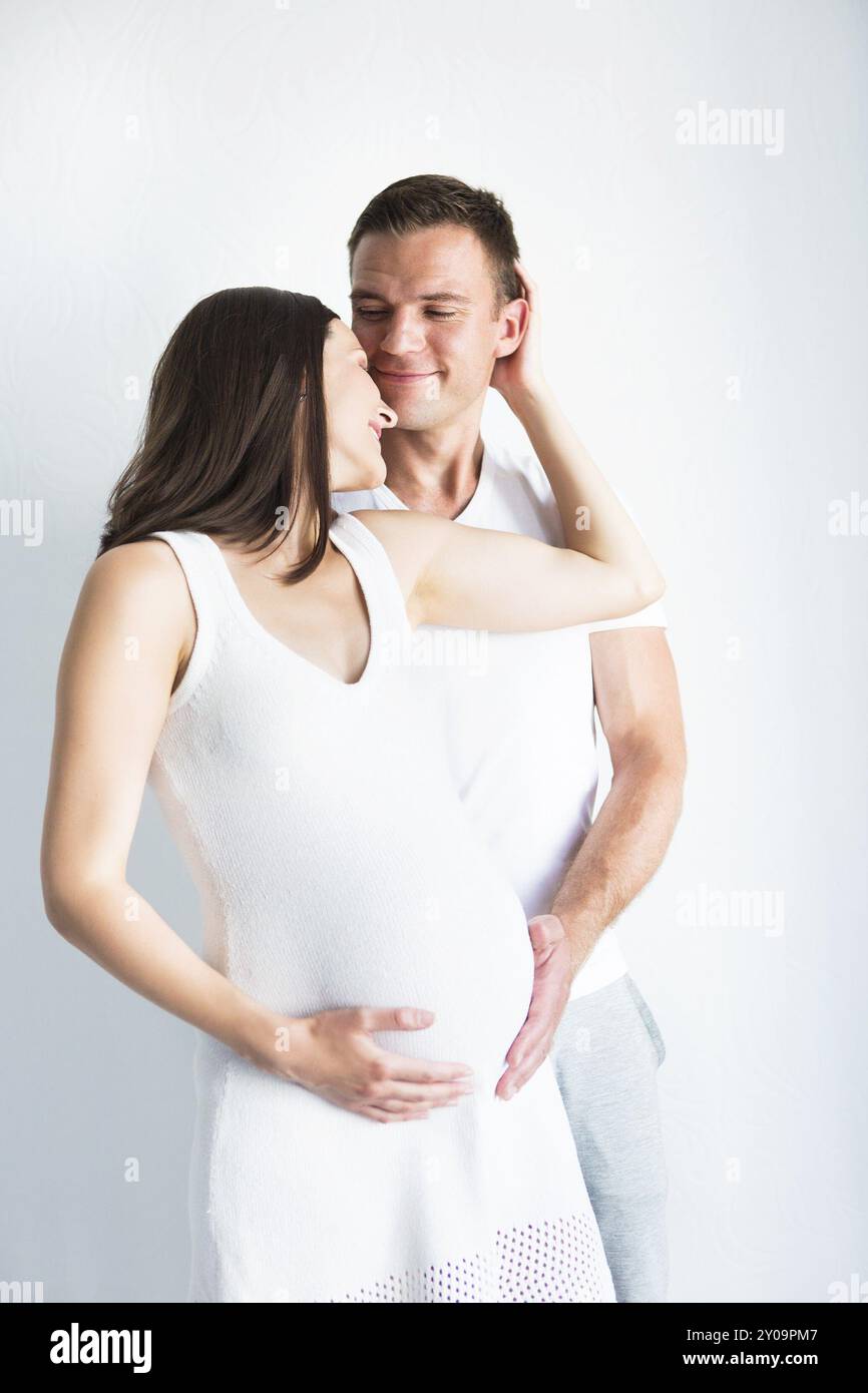 Young man and pretty pregnant woman hugging together indoors Stock ...